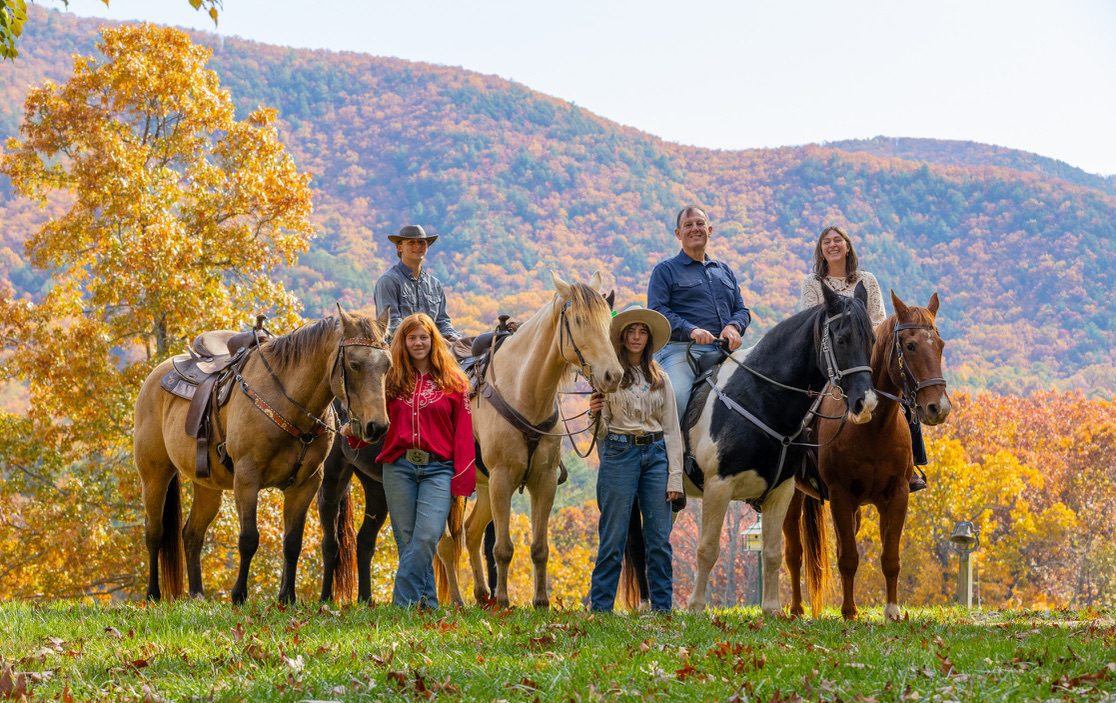 The Thompson family on horseback in front of fall color in the Blue Ridge