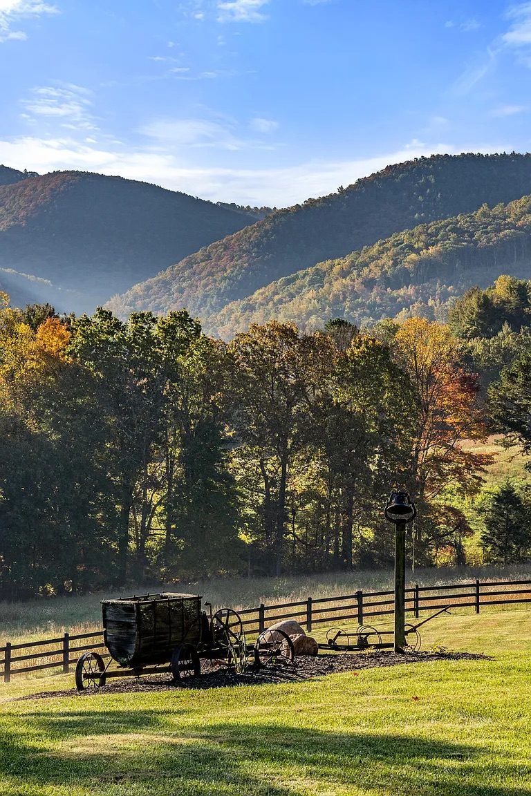 Antique farm wagon on a fence line with the Blue Ridge mountains behind it